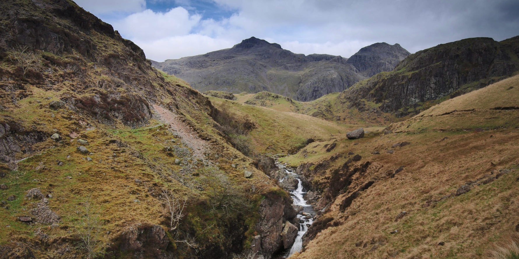 A view towards Scafell Pike and its neighbouring fells from the Esk Gorge on a spring day.
